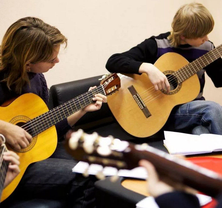 Девушка с мальчиком играют на гитаре